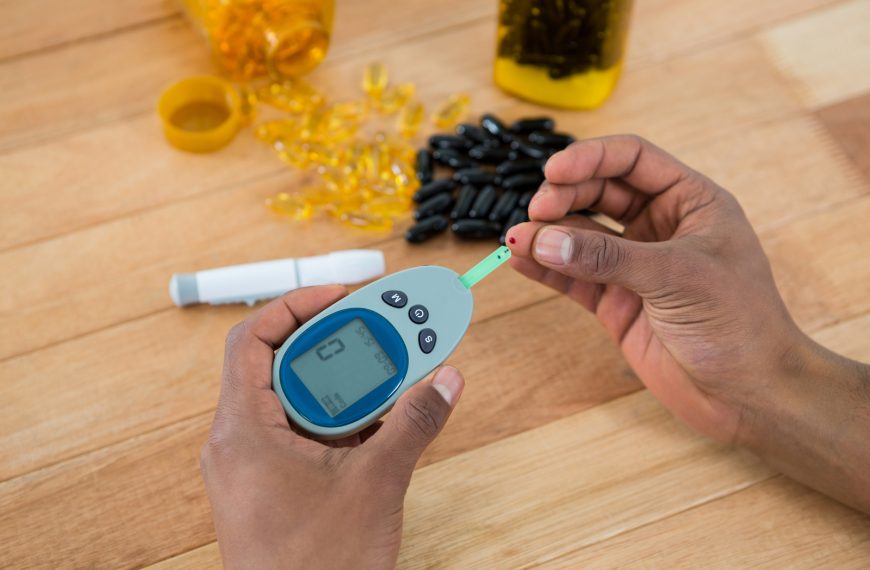 person checking blood sugar with glucometer image.